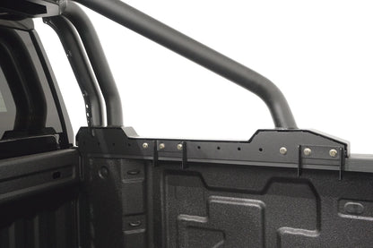 Close-up of the Fab Fours Sport Rack bed rail mount, showing the adjustable clamp brackets, bolt-on hardware and tubular bars over the truck bed