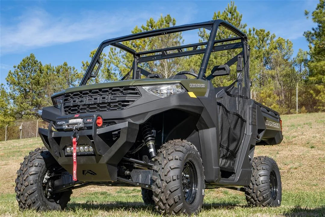Fab Fours SxS winch bumper on a green Polaris Ranger 1000 parked on grass, low driver-side front three-quarter view, with Warn Axon winch and LED light bar
