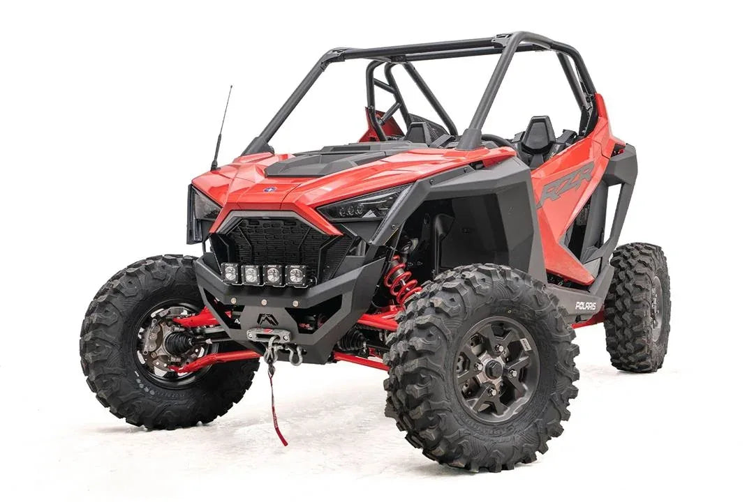 Fab Fours SxS winch bumper on a red Polaris RZR Pro XP, driver-side front three-quarter view, with four cube lights and winch