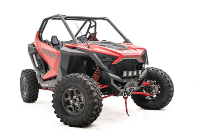 Fab Fours SxS winch bumper on a red Polaris RZR Pro XP, passenger-side front three-quarter view, with four cube lights and winch