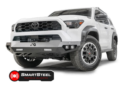 Fab Fours Vengeance front sensor bumper on a white Toyota 4Runner, driver-side front three-quarter view, showing the angular bumper, LED light bars and cube lights