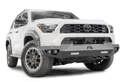 Fab Fours Vengeance front sensor bumper on a white Toyota 4Runner, passenger-side front three-quarter view, showing the angular bumper, LED light bars and skid plate