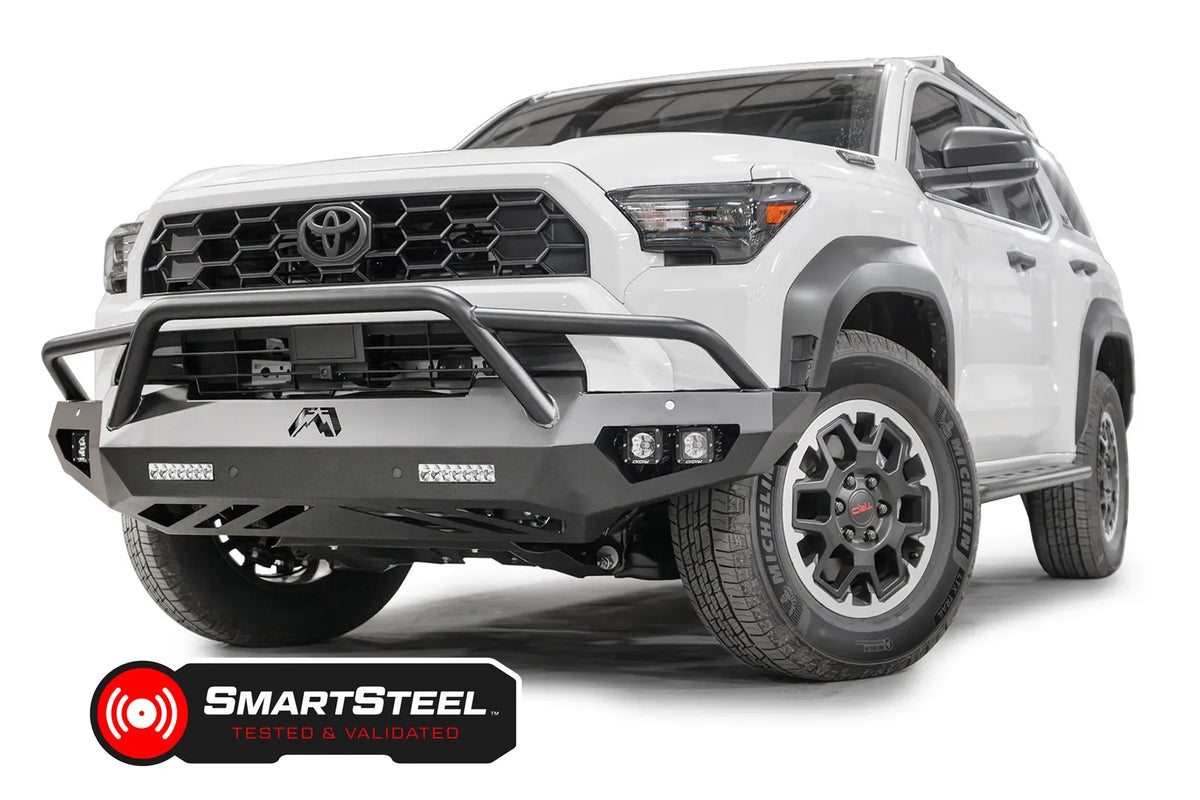 Fab Fours Vengeance front sensor bumper with pre-runner guard on a white Toyota 4Runner, driver-side front three-quarter view, showing the tube hoop, LED light bars and cube lights