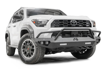 Fab Fours Vengeance front sensor bumper with pre-runner guard on a white Toyota 4Runner, passenger-side front three-quarter view, showing the tube hoop, LED light bars and skid plate