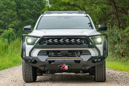 Fab Fours Matrix front winch bumper with full guard on a white Toyota 4Runner on a gravel road, straight-on front view, showing the full guard, LED light bar and winch with red hook