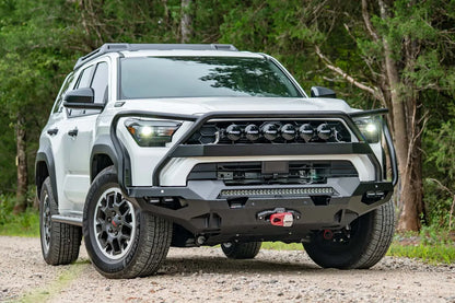 Fab Fours Matrix front winch bumper with full guard on a white Toyota 4Runner outdoors, passenger-side front three-quarter view, showing the full guard, light bar and winch