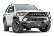 Fab Fours Matrix front winch bumper with full guard on a white Toyota 4Runner, passenger-side front three-quarter view, showing the full guard, LED light bar and winch with red hook