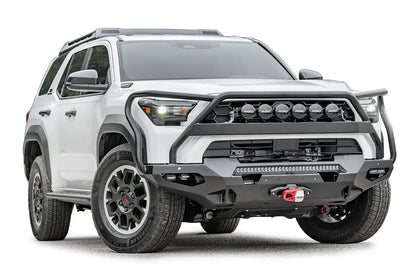 Fab Fours Matrix front winch bumper with full guard on a white Toyota 4Runner, passenger-side front three-quarter view, showing the full guard, LED light bar and winch with red hook