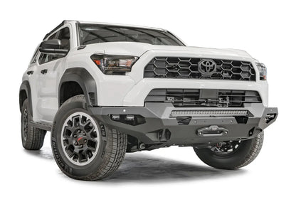 Fab Fours Matrix front winch bumper on a white Toyota 4Runner, passenger-side front three-quarter view, showing the bumper, LED light bar and winch fairlead