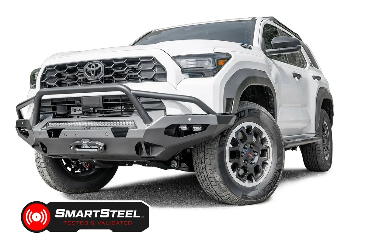 Fab Fours Matrix front winch bumper with pre-runner guard on a white Toyota 4Runner, driver-side front three-quarter view, showing the tube hoop, LED light bar and winch fairlead