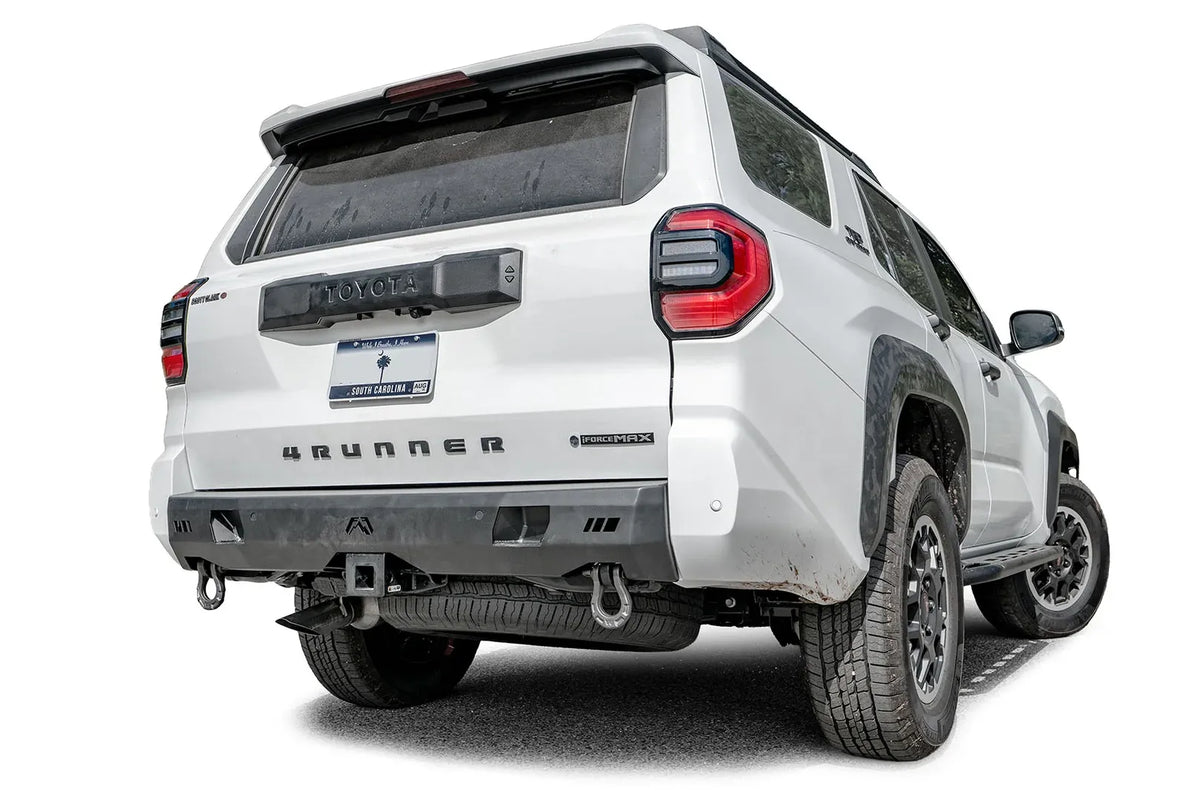 Fab Fours Premium rear bumper on a white Toyota 4Runner, passenger-side rear three-quarter view, with D-ring shackles and hitch receiver