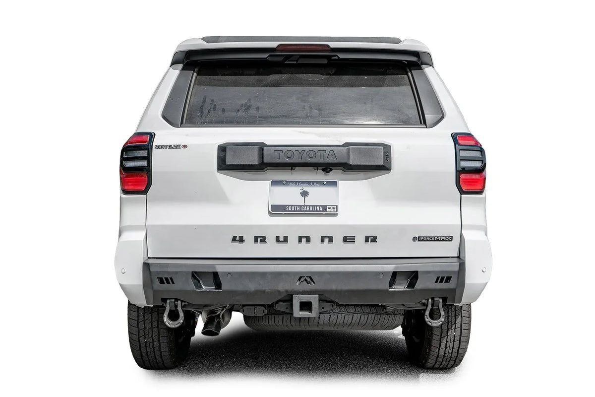 Fab Fours Premium rear bumper on a white Toyota 4Runner, straight rear view, with parking sensors, D-ring shackles, and center hitch receiver