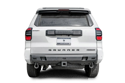 Fab Fours Premium rear bumper on a white Toyota 4Runner, straight rear view, with parking sensors, D-ring shackles, and center hitch receiver