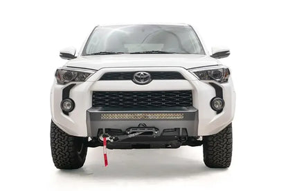 Fab Fours Hidden Winch Mount on a white Toyota 4Runner, front view, showing the low-profile winch plate, LED light bar and fairlead