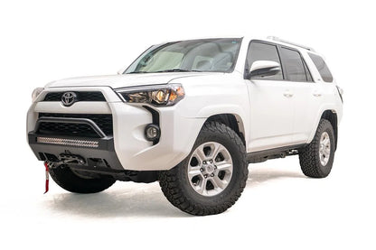 Fab Fours Hidden Winch Mount with low pre-runner guard on a white Toyota 4Runner, front three-quarter view from the driver side, showing the pre-runner hoop, LED light bar and red winch strap