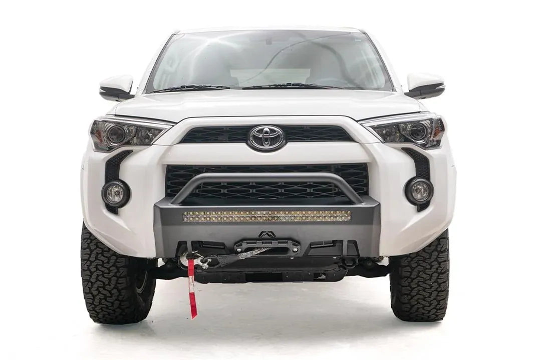 Fab Fours Hidden Winch Mount with low pre-runner guard on a white Toyota 4Runner, front view, showing the low pre-runner hoop, LED light bar and winch fairlead
