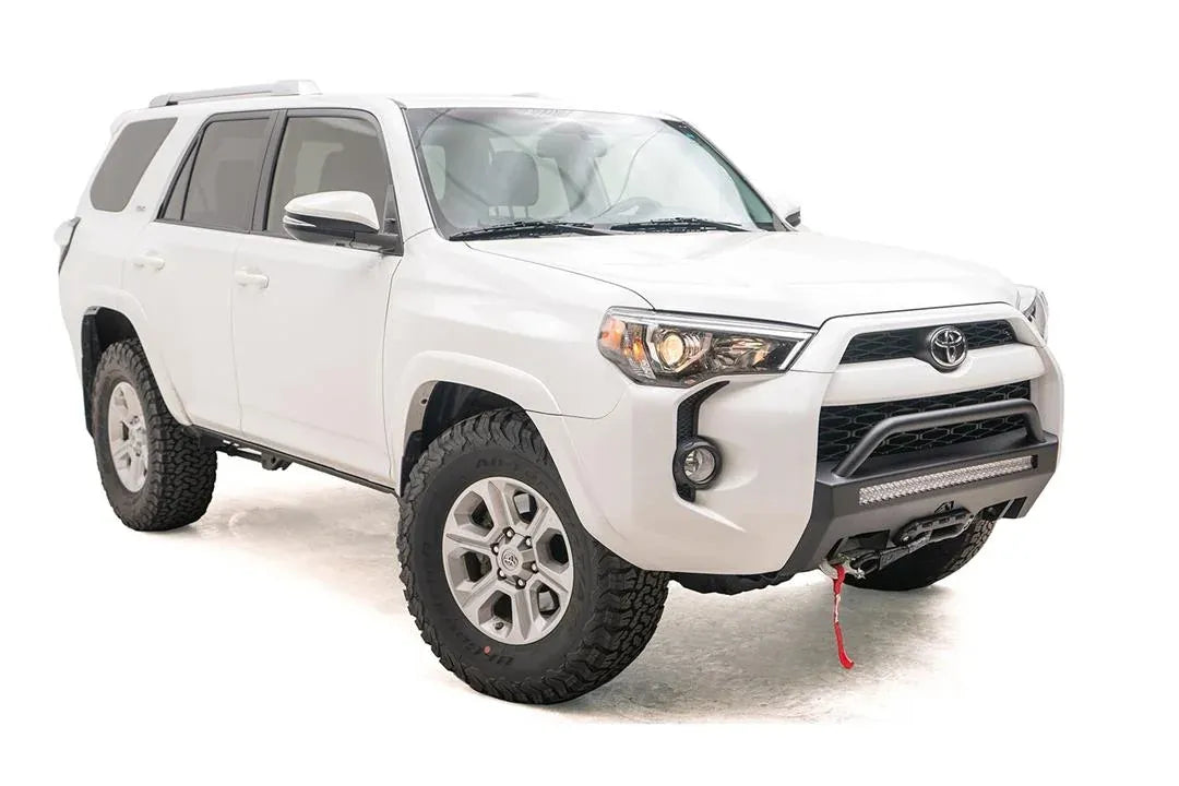 Fab Fours Hidden Winch Mount with low pre-runner guard on a white Toyota 4Runner, front three-quarter view from the passenger side, showing the pre-runner hoop, LED light bar and winch line