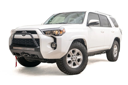 Fab Fours Hidden Winch Mount with high pre-runner guard on a white Toyota 4Runner, front three-quarter view from the driver side, showing the high pre-runner hoop, LED light bar and red winch strap