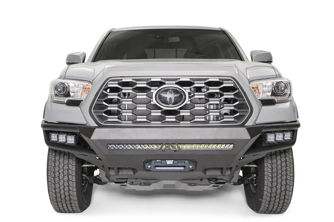 Fab Fours Hybrid front bumper on a silver Toyota Tacoma, front view, showing the LED light bar, cube lights and centre winch opening