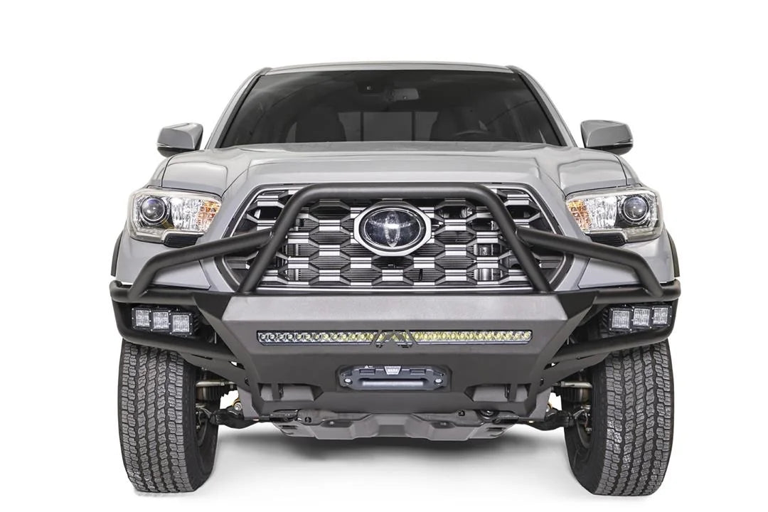 Fab Fours Hybrid front bumper with full guard on a silver Toyota Tacoma, front view, showing the full grille guard, the LED light bar, cube lights and centre winch opening