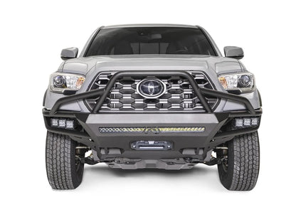 Fab Fours Hybrid front bumper with full guard on a silver Toyota Tacoma, front view, showing the full grille guard, the LED light bar, cube lights and centre winch opening