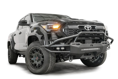 Fab Fours Hybrid front bumper with pre-runner guard on a black Toyota Tacoma, front three-quarter view from the passenger side, showing the pre-runner hoop, tube wings and LED light bar