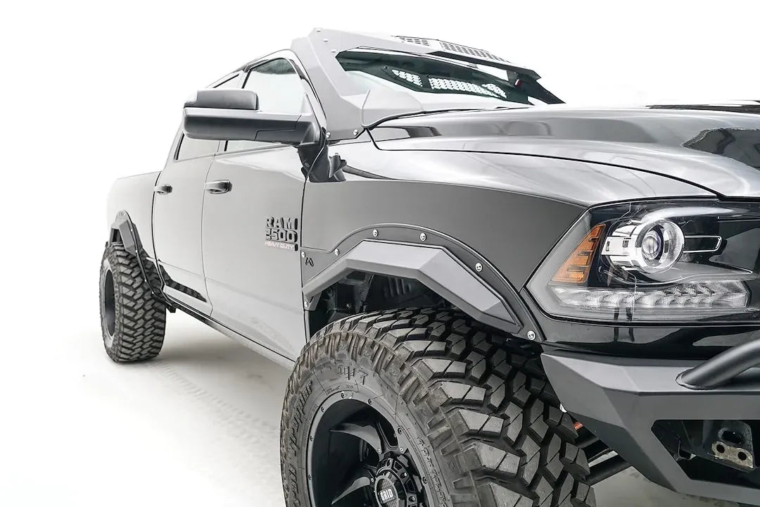 Fab Fours Open Fender Flares on a black Ram 2500 crew cab, close-up of the front fender, showing the front open fender flare, bolt detail and tire clearance