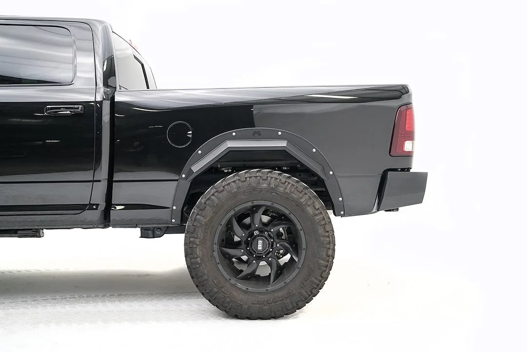 Fab Fours Open Fender Flares on a black Ram 2500 crew cab, close-up of the rear wheel opening, showing the rear open fender flare, exposed bolts and tire clearance