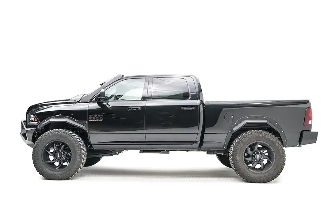 Fab Fours Open Fender Flares on a black Ram 2500 crew cab, driver-side profile view, showing the front and rear open fender flares and raised wheel openings