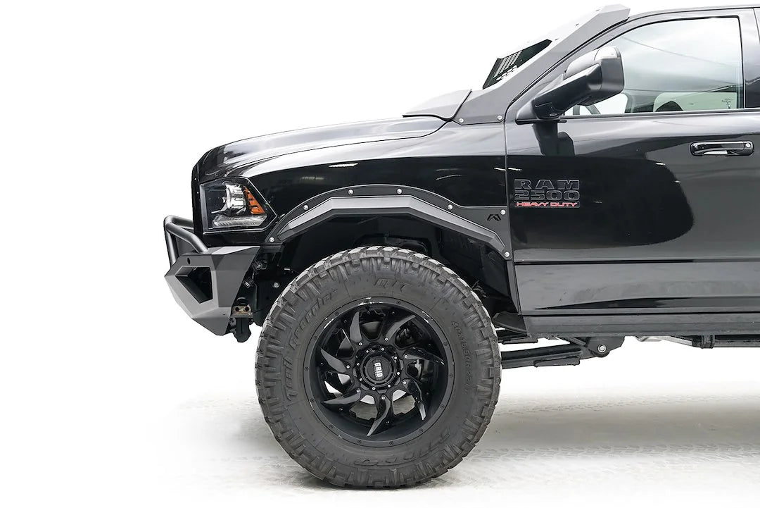 Fab Fours Open Fender Flares on a black Ram 2500 crew cab, close-up of the front fender from the driver side, showing the front open fender flare, bolt detail and tire clearance