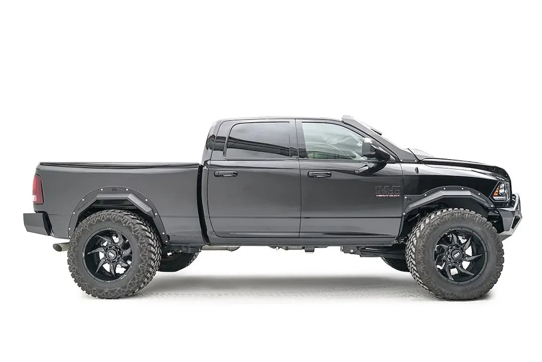 Fab Fours Open Fender Flares on a black Ram 2500 crew cab, passenger-side profile view, showing the front and rear open fender flares and raised wheel openings