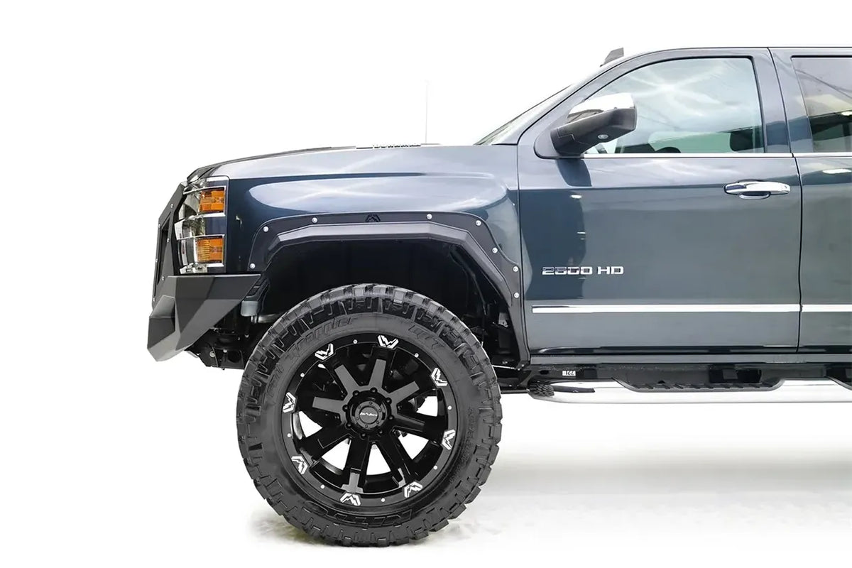 Fab Fours Open Fender Flares on a dark blue Chevrolet 2500HD, close-up of the front fender, showing the front open fender flare, exposed bolts and tire clearance