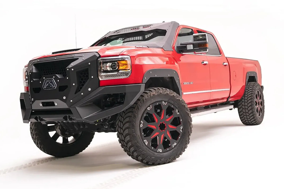 Fab Fours open fender system on a lifted red GMC Sierra 3500HD, driver-side front three-quarter view, with Fab Fours Grumper front bumper and red and black wheels