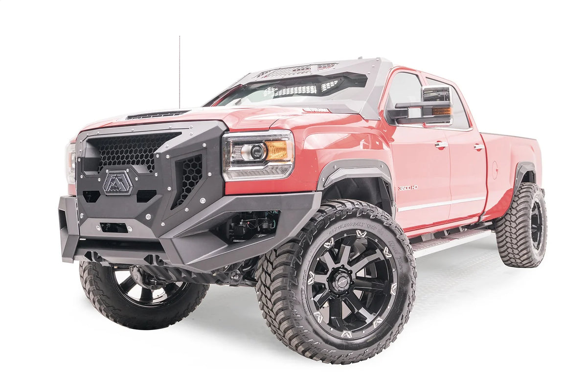 Fab Fours open fender flares on a lifted red GMC Sierra 3500HD, driver-side front three-quarter view, with Fab Fours Grumper front bumper and cab roof visor
