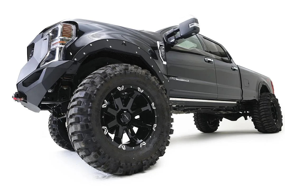 Fab Fours Open Fender System on a black Ford F-250 Super Duty, low-angle close-up of the front fender, showing the open front fender, bolt-on trim and tire clearance