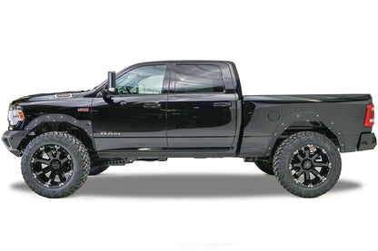 Fab Fours Open Fender System on a black Ram 2500 crew cab, driver-side profile view, showing the open front and rear fenders and raised wheel openings