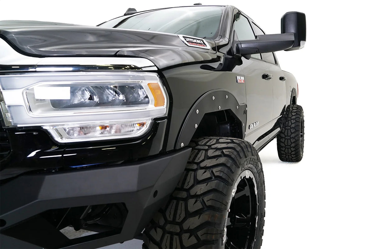 Fab Fours Open Fender System on a black Ram 2500 crew cab, close-up of the front fender from the driver side, showing the open front fender, bolt-on trim and tire clearance
