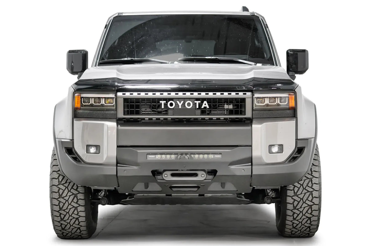 Fab Fours Hidden Winch Mount on a silver Toyota Land Cruiser, front view, showing the low-profile winch plate, LED light bar and winch fairlead