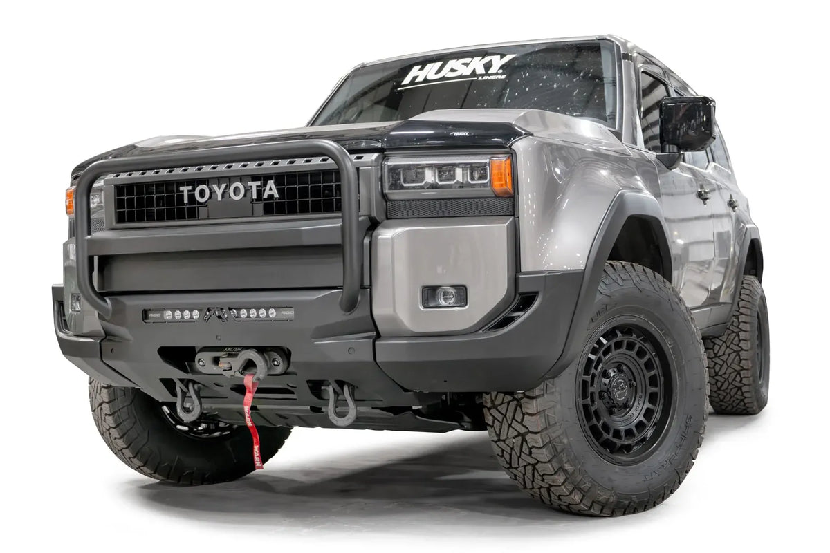 Fab Fours Hidden Winch Mount with pre-runner guard on a silver Toyota Land Cruiser, front three-quarter view from the driver side, showing the pre-runner guard, LED light bar and winch fairlead