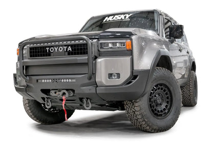 Fab Fours Hidden Winch Mount with pre-runner guard on a silver Toyota Land Cruiser, front three-quarter view from the driver side, showing the pre-runner guard, LED light bar and winch fairlead