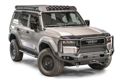 Fab Fours Roof Rack on a silver Toyota Land Cruiser, front passenger-side view, with six RIGID round lights mounted on the front wind fairing