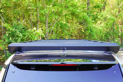 Fab Fours Roof Rack on a Toyota Land Cruiser outdoors, rear view, showing the black rear rail with Fab Fours logo above the rear window