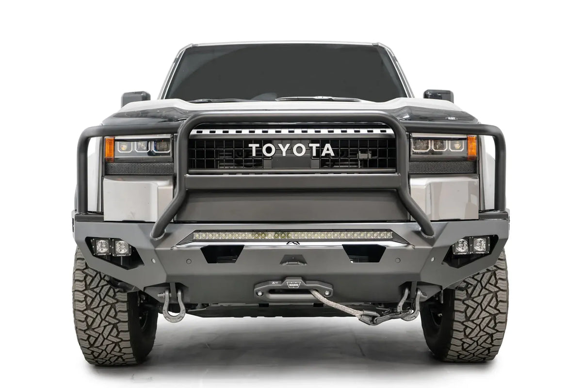 Fab Fours Matrix front bumper with full guard on a silver Toyota Land Cruiser, front view, showing the full grille guard, LED light bar, cube lights and winch fairlead