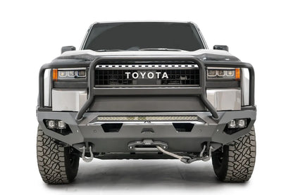 Fab Fours Matrix front bumper with full guard on a silver Toyota Land Cruiser, front view, showing the full grille guard, LED light bar, cube lights and winch fairlead
