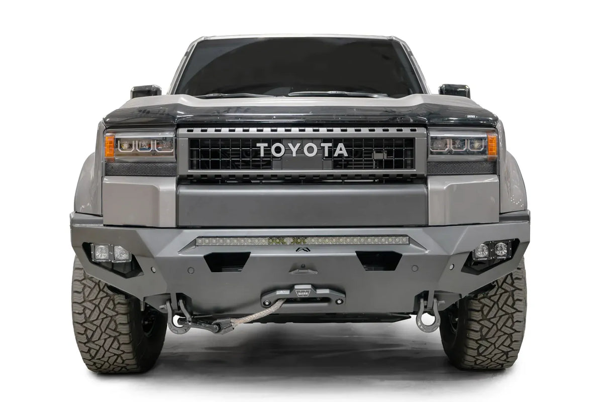 Fab Fours Matrix front bumper on a silver Toyota Land Cruiser, front view, showing the LED light bar, cube lights, winch fairlead and D-ring shackles