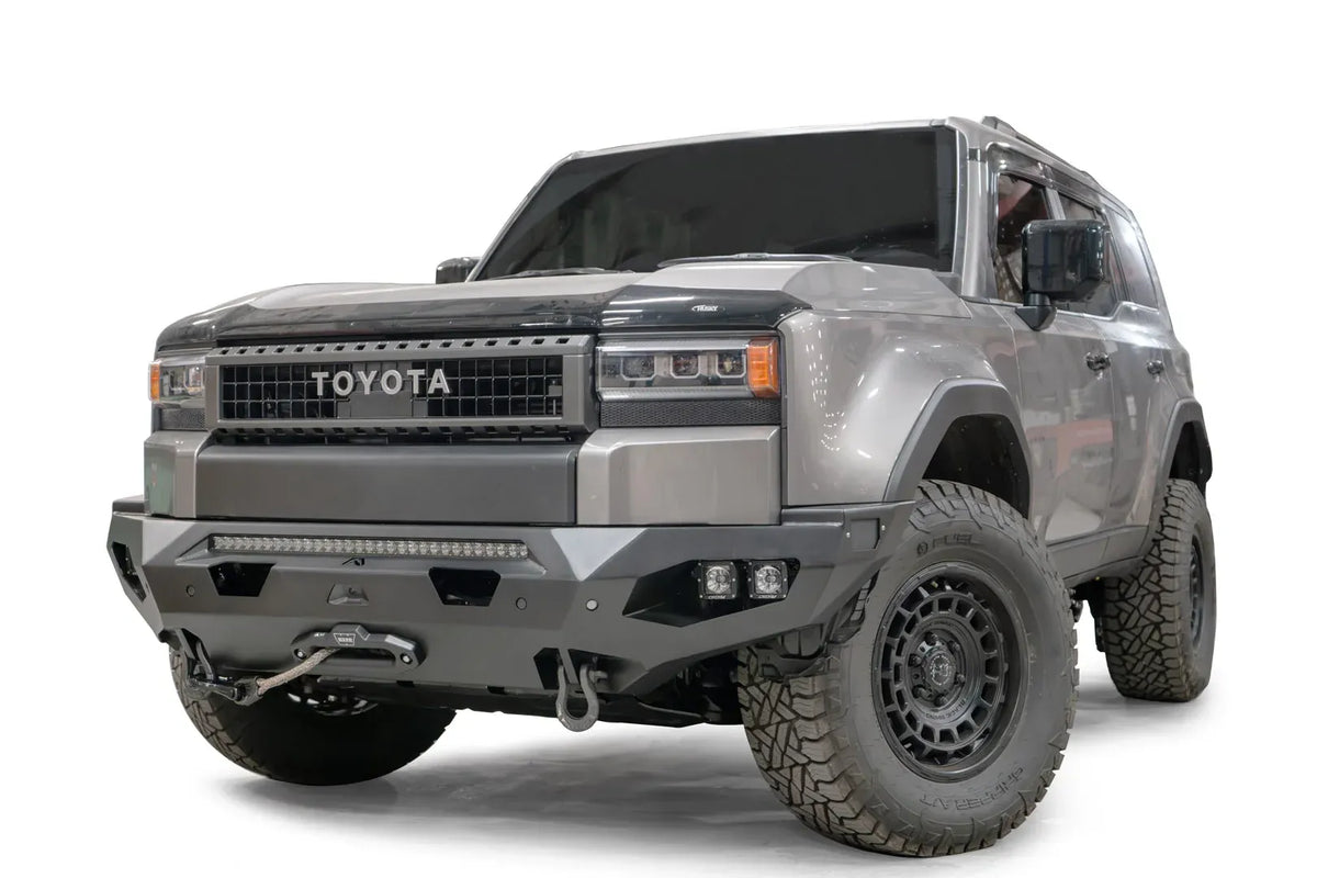 Fab Fours Matrix front bumper on a silver Toyota Land Cruiser, front three-quarter view from the driver side, showing the LED light bar, cube lights and winch fairlead