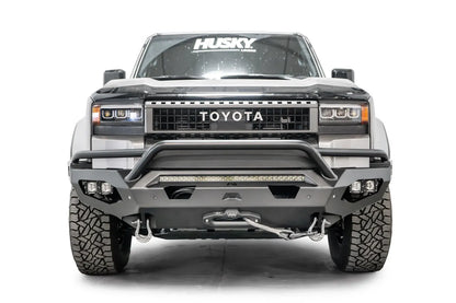 Fab Fours Matrix front bumper with pre-runner guard on a silver Toyota Land Cruiser, front view, showing the pre-runner hoop, LED light bar, cube lights and winch fairlead