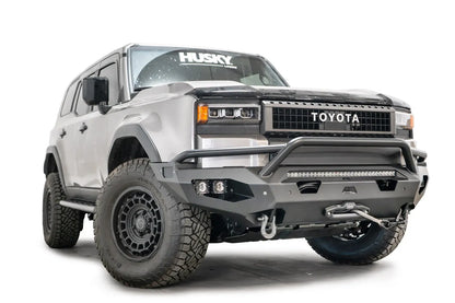 Fab Fours Matrix front bumper with pre-runner guard on a silver Toyota Land Cruiser, front three-quarter view from the passenger side, showing the pre-runner hoop, LED light bar and cube lights