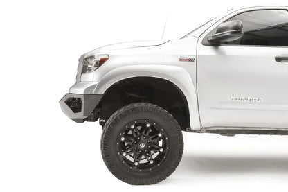 Fab Fours Vengeance front bumper on a silver Toyota Tundra, close-up of the front corner from the side, showing the bumper end and wheel clearance