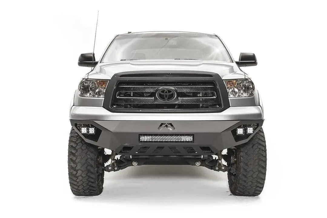 Fab Fours Vengeance front bumper on a silver Toyota Tundra, front view, showing the LED light bar, cube lights and skid plate